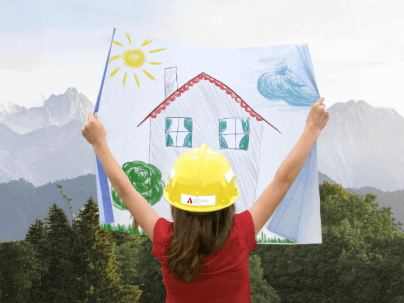 Mädchen mit gezeichnetem Haus vor Bergkulisse
